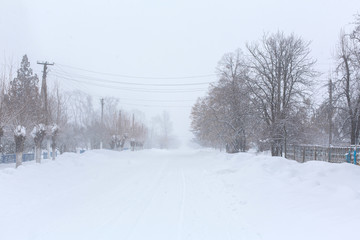 Winter, rural streets are covered with snow. Snow blizzard