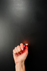 Lighter in a female hand. Black background