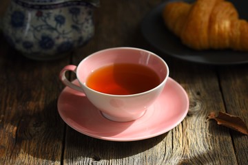 Pink Cup with fragrant tea on a wooden background. Tea mood. Tea composition.