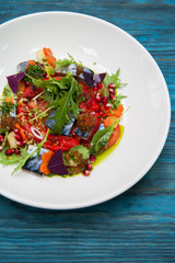 Escabeche fish dish with caviar: mackerel in marinade with vegetable, on a plate on the wooden blue background.