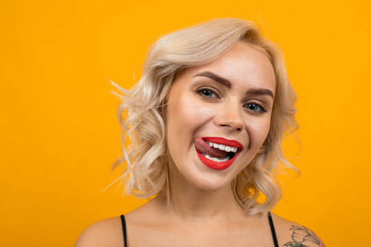 portrait of a sexy glamorous blonde girl with beautiful makeup on a yellow background