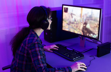 Concentrated gamer girl playing first person shooter
