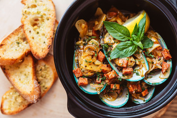 Top view of Steamed New Zealand Mussel with chorizo sausage, lemon  and white wine sauce. Served with garlic bread.