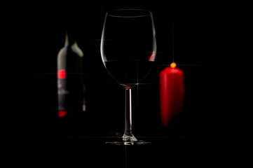 Red wine bottle, glass of wine and candle