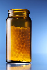 globuli in einer braunen glasflasche