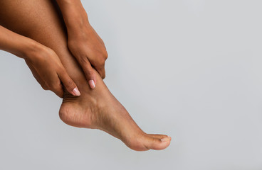 Close up of black woman massaging her ankle