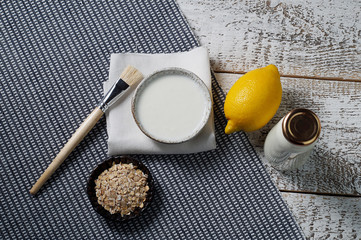 Oatmeal, kefir, lemon-ingredients for making a face mask. Brush for application, napkin, top view, horizontal position. The fermented product is a home cooking.