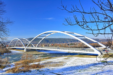 View of new steel bridge cross the Dunajec river in winter sunny day, Nowy Sacz, Poland