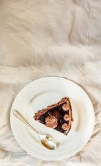 Dark Chocolate Cake with Chocolate Glaze for Holiday and cup of coffee. White linen tablecloth background. Top view.