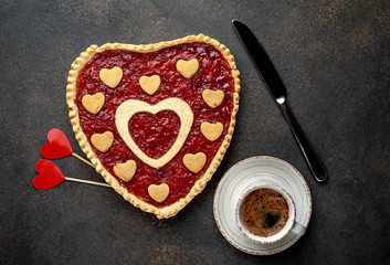 coffee, heart-shaped cake, a gift with a red ribbon for Valentine's Day on  stone background, with copy space for your text. breakfast concept on  saint's day  Valentine.