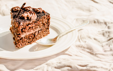 Freshly made delicious chocolate cake on a white linen tablecloth background. Kinfolk and sweet food atmosphere concept. Close up. Horizontal