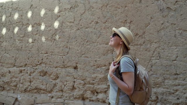 Caucasian Female Tourist Walking along Streets of Abandoned Old Ruined Village of Al Hamra near Nizwa, Oman