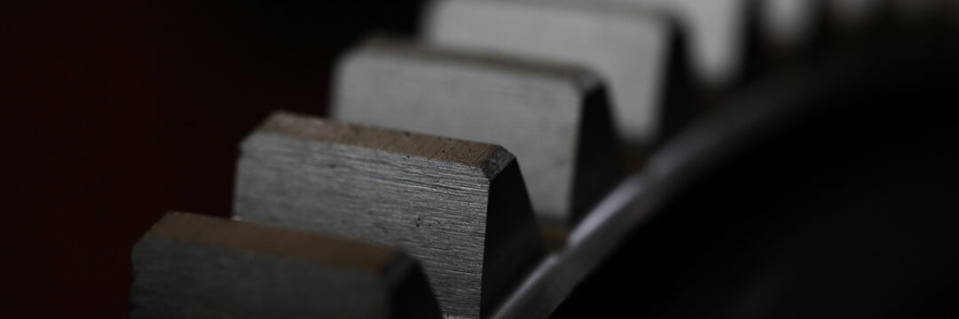 Closeup of metal cogwheel on dark background as part of full machine and steampunk concept
