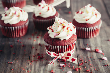 Red velvet cupcakes on a rustic wooden table for Valentines day