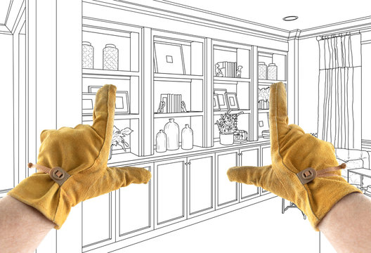 Male Contractor Hands Framing Over Built In Design Drawing