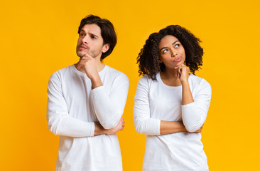 Portrait of pensive interracial couple thinking about something and looking away