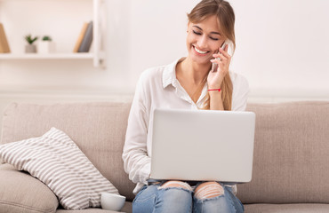 Woman Talking On Phone Working On Laptop Sitting On Couch