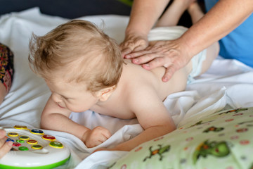 Obraz na płótnie Canvas Baby having back massage in a rehabilitation center. Little child on therapy. Massage therapist massaging a baby.