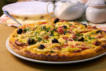 Fresh and very tasty pizza with olives and tomatoes on the table