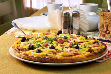 Fresh and very tasty pizza with olives and tomatoes on the table