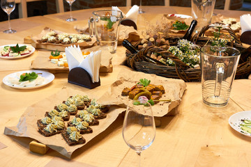 Served wooden table with a set of variety snacks, different vegetable salads, salad, pickle carrot, kavarma, rye bread sandwiches with soft cheese cream, fruits,