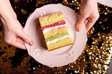 Golden brilliant tasty cake is cut into pieces. A slice of cake on a pink plate. Homemade baking for a children's party.