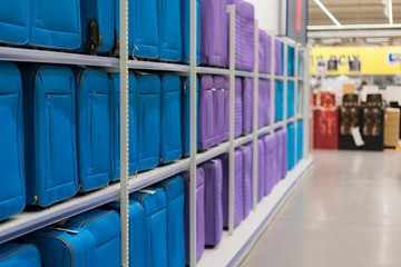 Blue and purple suitcases on a shelf in a store. Travel concept