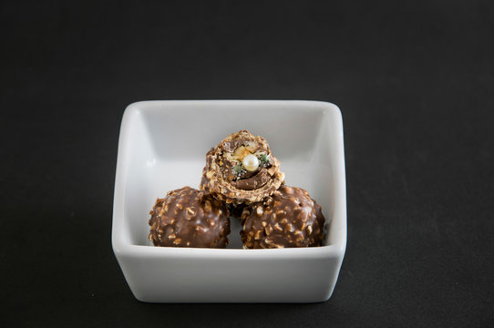 Bombones de chocolate de los que aparece un anillo con una perla como sorpresa.