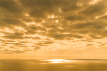 Naklejka na ściany i meble Yellow Sunset on the sea with overcast sky. Orange pastel tone