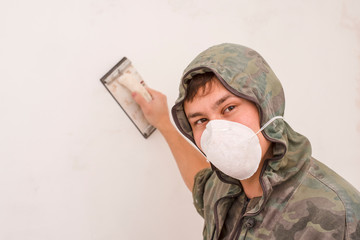 A young man grinds the wall after putty