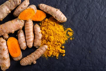 Fotobehang Food and drink, diet nutrition, health care concept. Raw organic orange turmeric root and powder, curcuma longa on a grunge cooking table. Indian oriental low cholesterol spices © ozgur