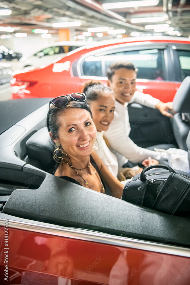 Sticker three happy friends smiling sitting in the back of a sports car