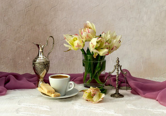 Still life with varietal tulips and a cup of coffee on a table close-up