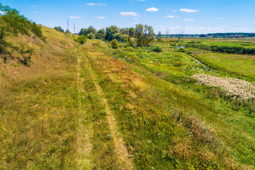 Summer rural landscape. Aerial view. View of the countryside. Country road on the hill
