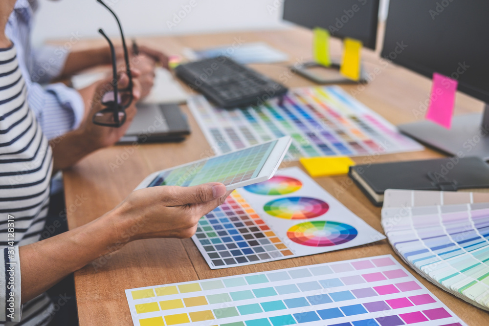 Poster Two colleagues creative graphic designer working on color selection and drawing on graphics tablet at workplace, Color swatch samples chart for selection coloring
