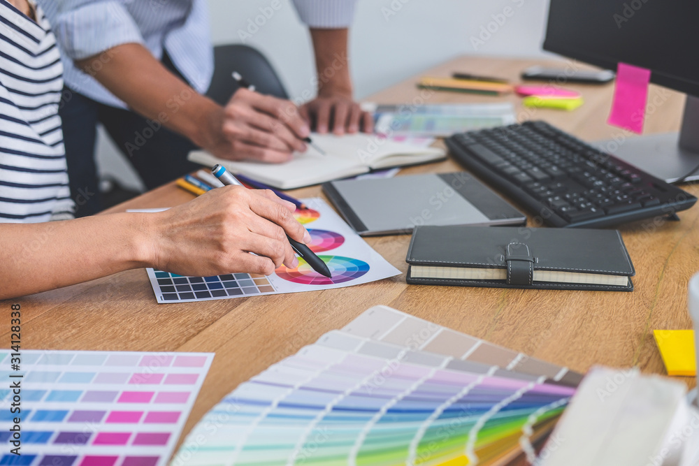 Poster Two colleagues creative graphic designer working on color selection and drawing on graphics tablet at workplace, Color swatch samples chart for selection coloring