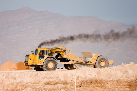 Heavy Construction Equipment Scraper Emitting Diesel Fumes