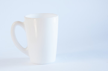 White cup for tea or coffee. On the table. On white background