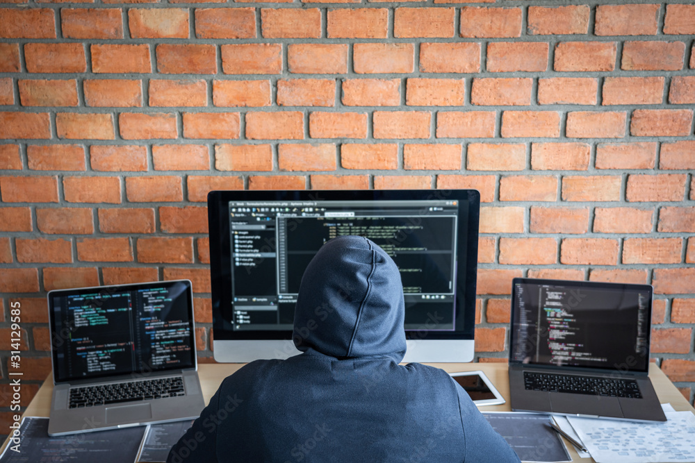 Poster Computer hacker or cyber attack concept, Dangerous hooded hacker using multiple computers typing bad data into online system the access with a virus to infect steal information