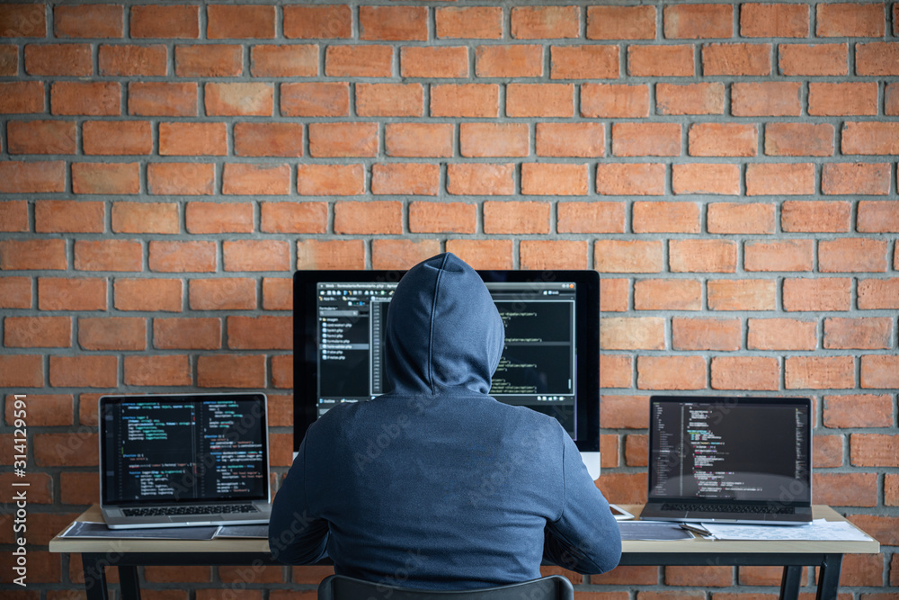 Leinwandbilder Computer hacker or cyber attack concept, Dangerous hooded hacker using multiple computers typing bad data into online system the access with a virus to infect steal information