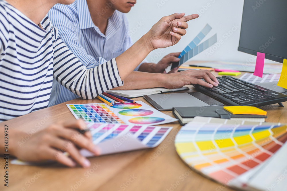 Aufkleber Two colleagues creative graphic designer working on color selection and drawing on graphics tablet at workplace, Color swatch samples chart for selection coloring