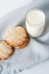Stacked cookies on a linen napkin and a glass of milk. Close up. Top view.