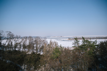 A spring sunny day in a snowy park