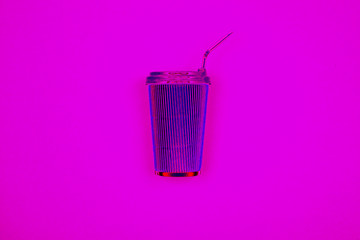 Neon pink reusable iron coffee cup on lilac background. Fragrant takeaway drink, layout for coffee. Business and service concept. Delicious morning hot drink. Bright hipster trendy design.