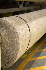 Large roll of beige carpet ready to be installed. home improvement store supplies for new construction and renovation of flooring