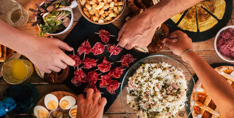 Top above view ot country style wooden table full of fresh hand made food and people hands taking eat to eat together in friendship -  concept of friends at home or restaurant eating lunch or dinner - obrazy, fototapety, plakaty