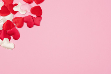 Red hearts for Valentine's day lie on a beautiful pink background. Heart pendant. Space for text. Red heart. Valentine Day.