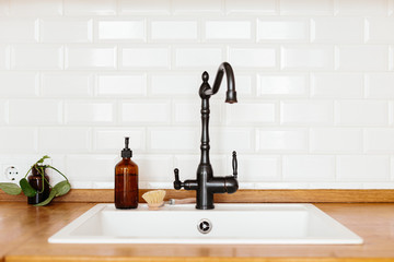 Kitchen with white sink and black faucet wooden countertop © laniko