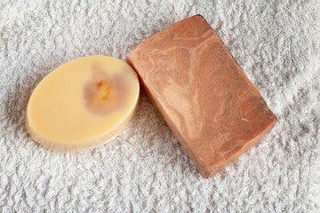 Bath accessories, handmade soap and white towel on blue background. Aromatherapy organic concept 