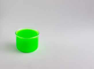 Jar with a toy called green slime on a light background. Funny toy for children's leisure and creativity. Selective focus.